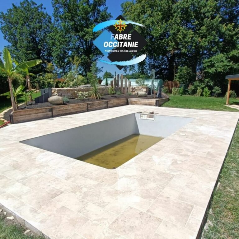 Fabre Occitanie - Une piscine extérieure aux carreaux beiges et à l'eau trouble sous un ciel clair, entourée d'une verdure luxuriante, avec un logo superposé dans le coin.