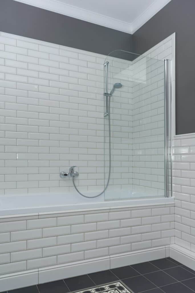 Fabre Occitanie - Coin salle de bain moderne avec cloison de douche en verre et carrelage métro blanc.