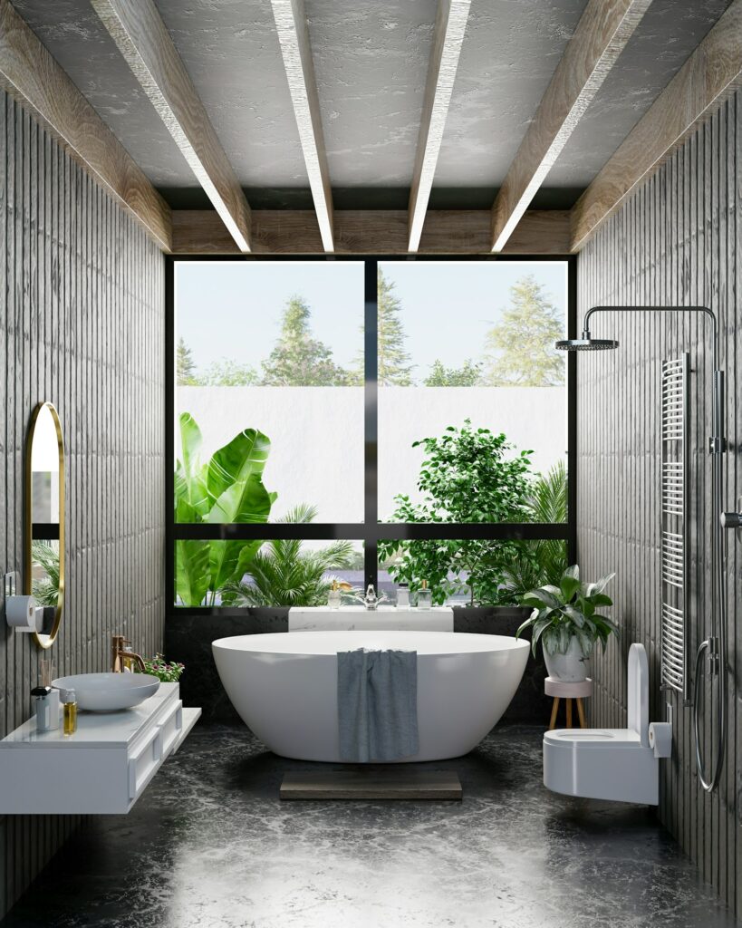 Fabre Occitanie - Salle de bain moderne avec bain autoportant, douche séparée et plantes vertes près d'une grande fenêtre offrant une vue extérieure sur Fabre Occitanie.