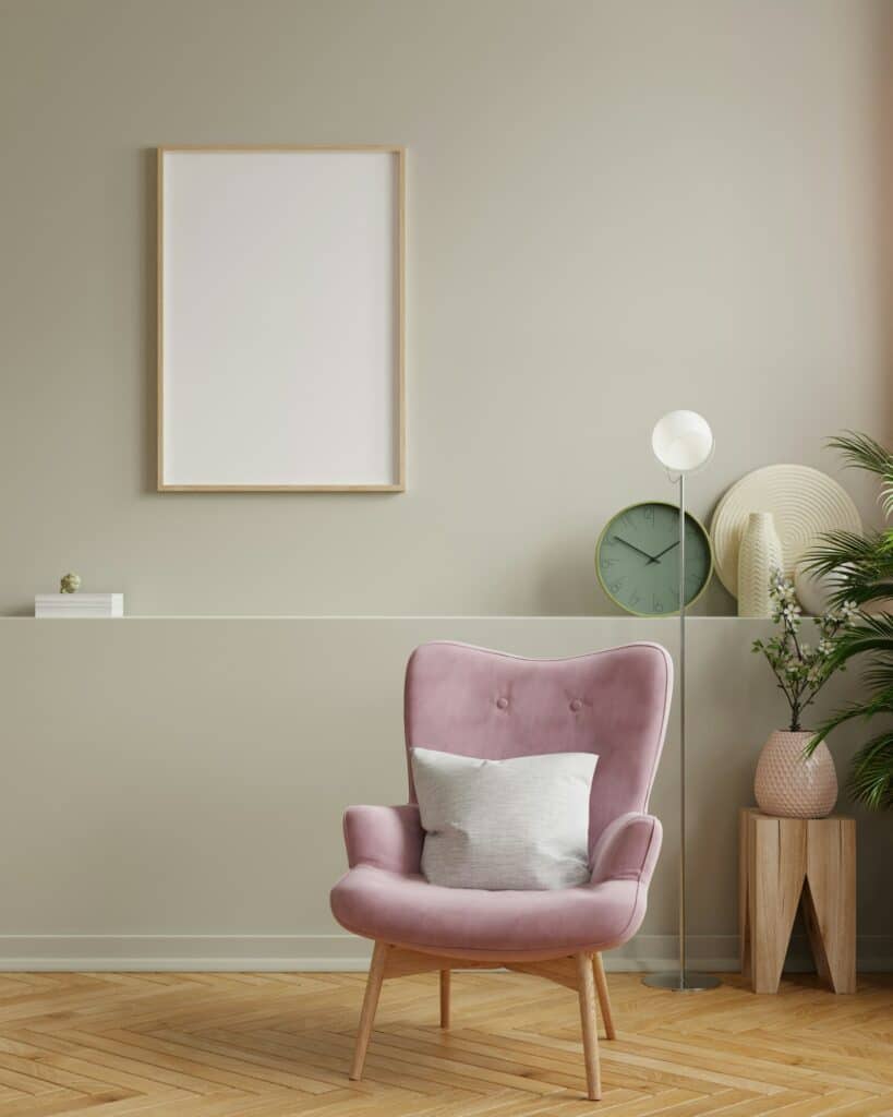 Fabre Occitanie - Un coin salon stylé avec un fauteuil rose, un coussin blanc, un lampadaire attenant et une affiche encadrée Fabre Occitanie au mur.